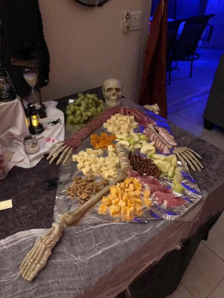 A Halloween charcuterie spread arranged with skeleton hands, bones, fruit, cheese, and meats at The Witch House in 2018