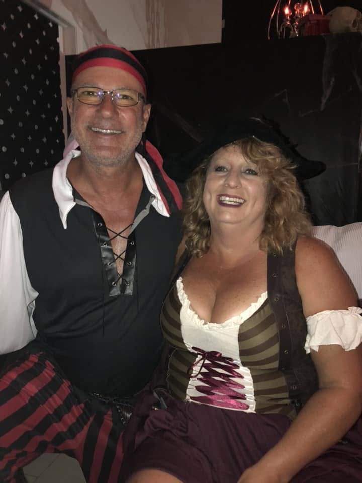 Two smiling guests dressed in pirate costumes posing together at The Witch House in 2018