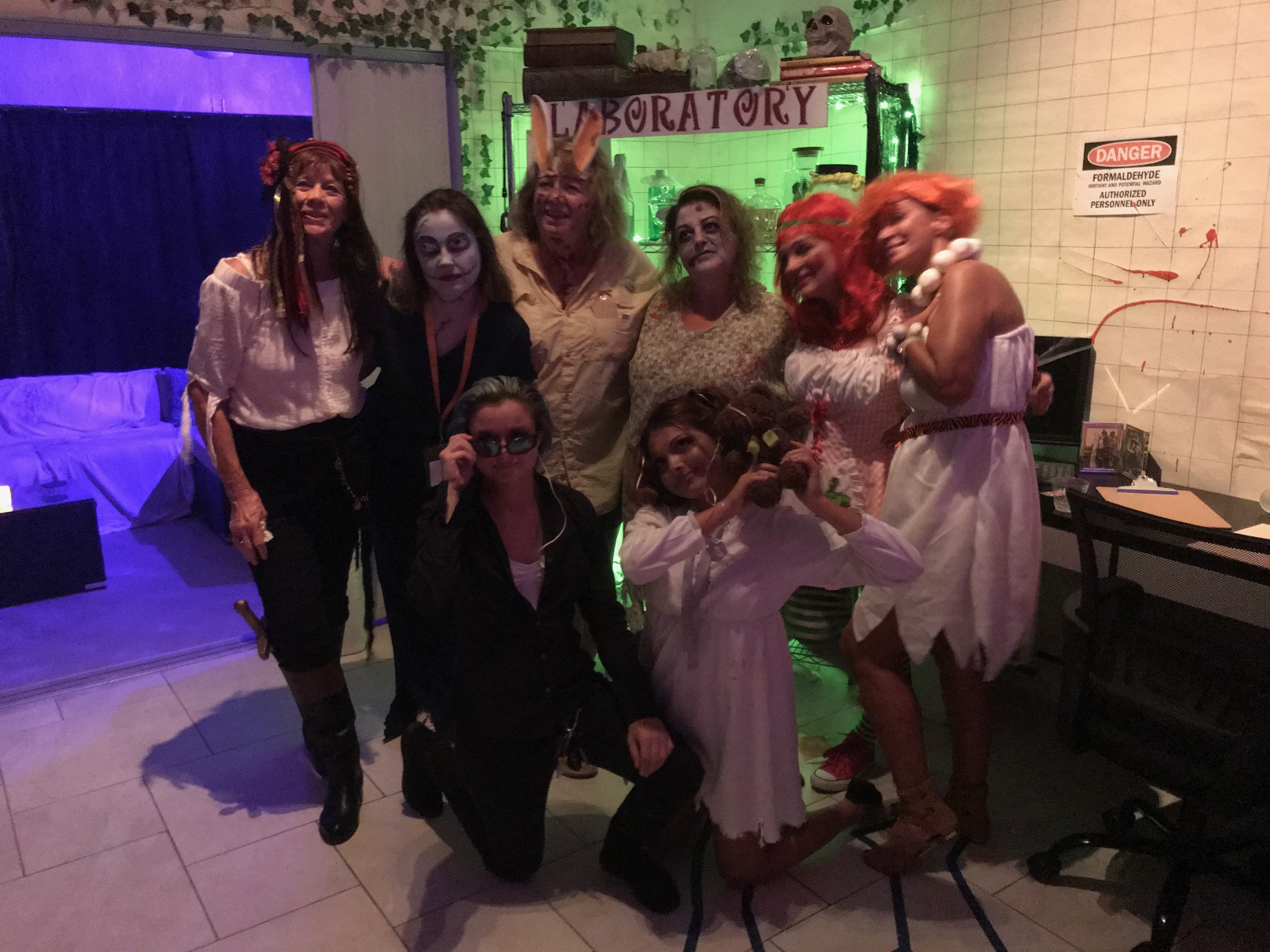 A larger group of costumed guests gathered inside the laboratory scene at the 2020 Halloween party