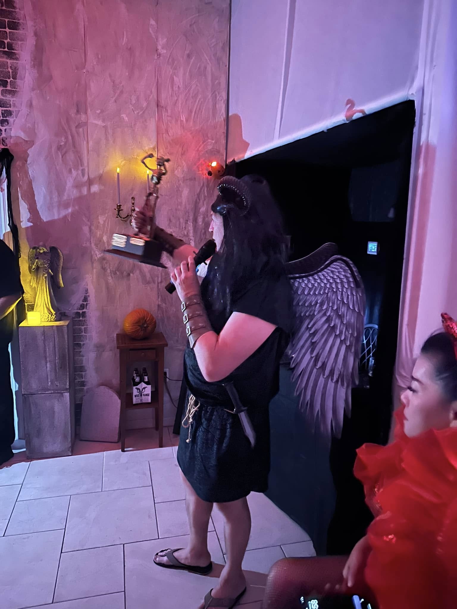 A winged guest holding The Skelly trophy during the 2023 party