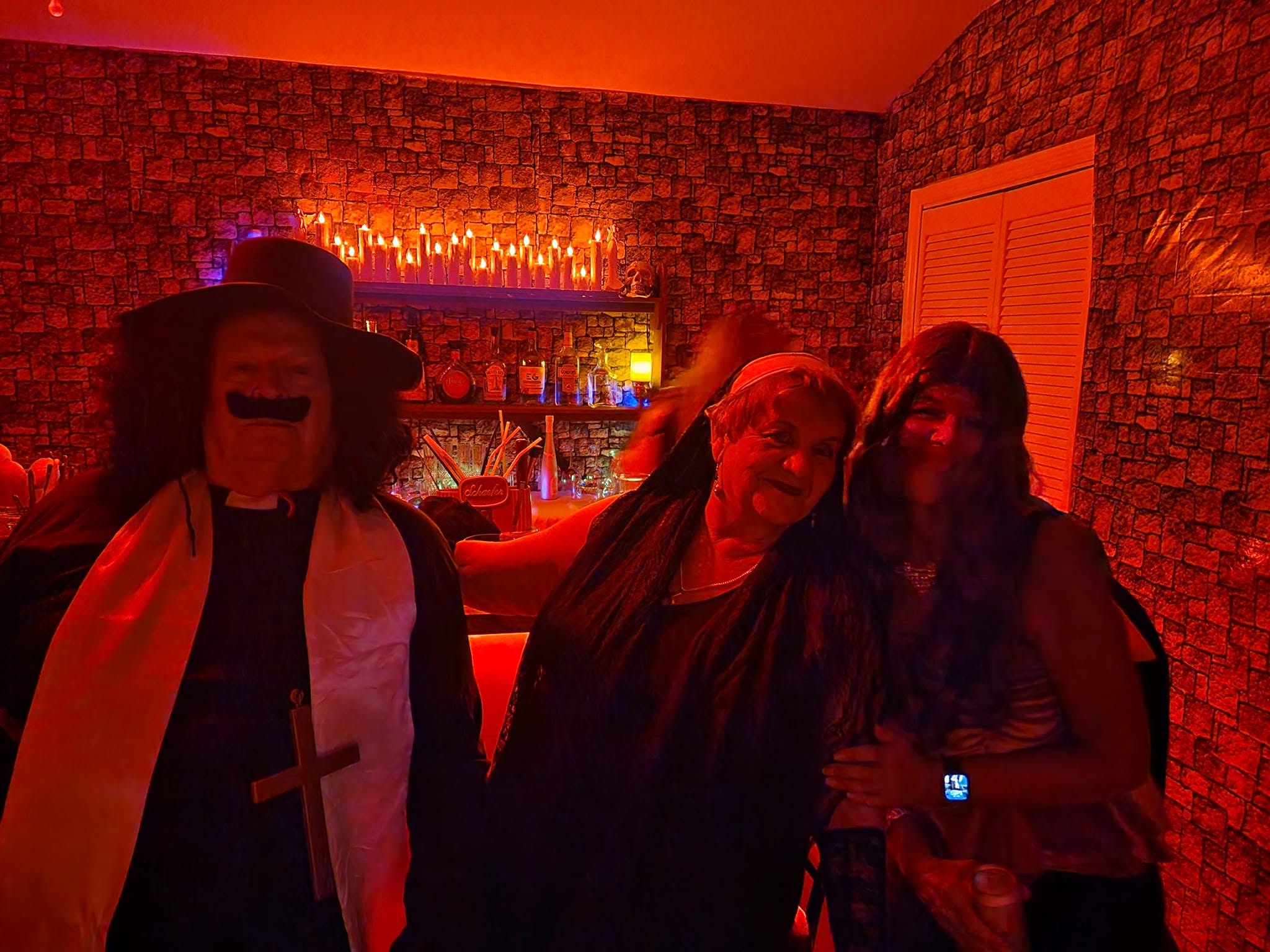A group of guests gathered in a candlelit red room at the 2023 party