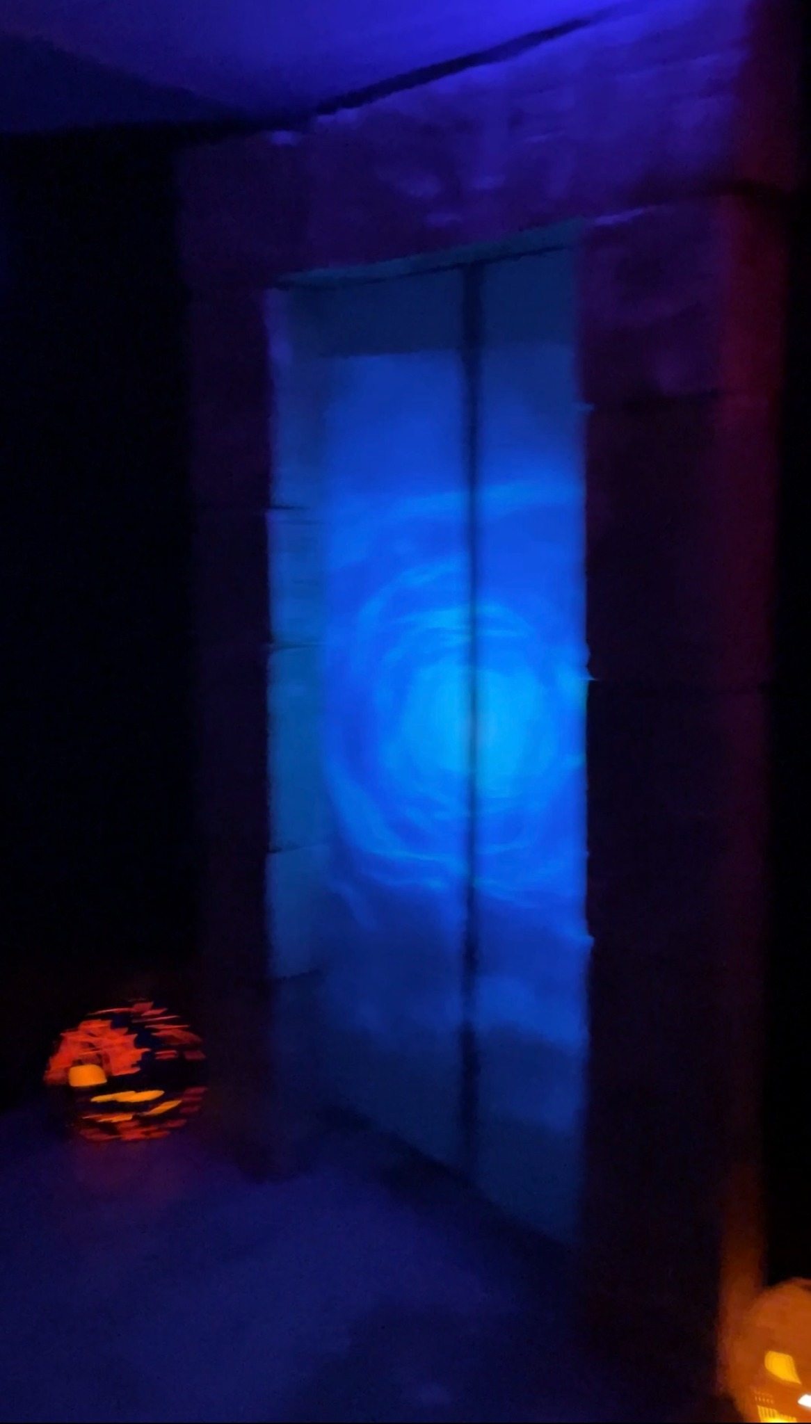A dim blue view of the glowing portal standing alone at the 2024 party
