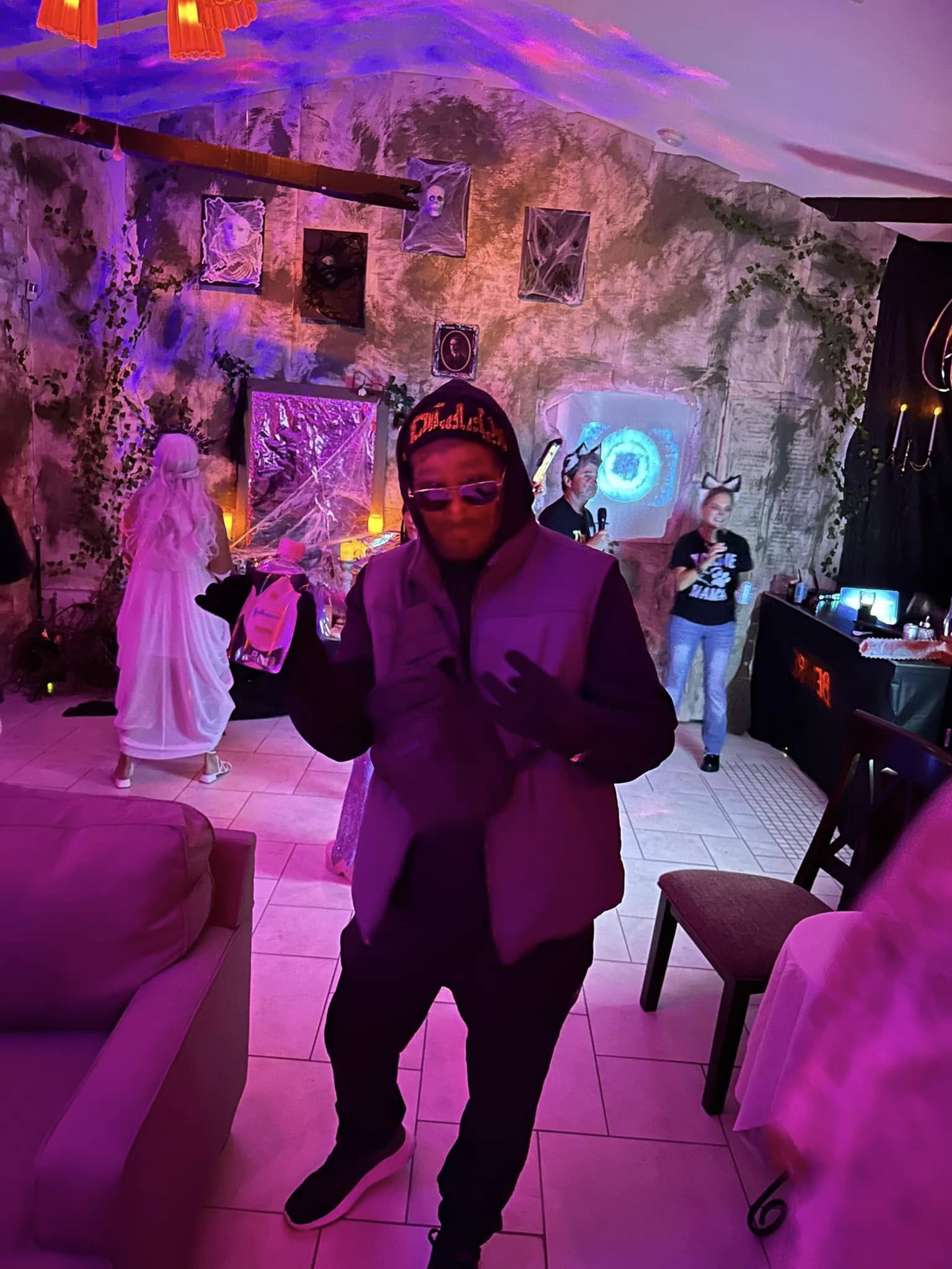 A wide room view with guests and the glowing portal in the background at the 2024 party