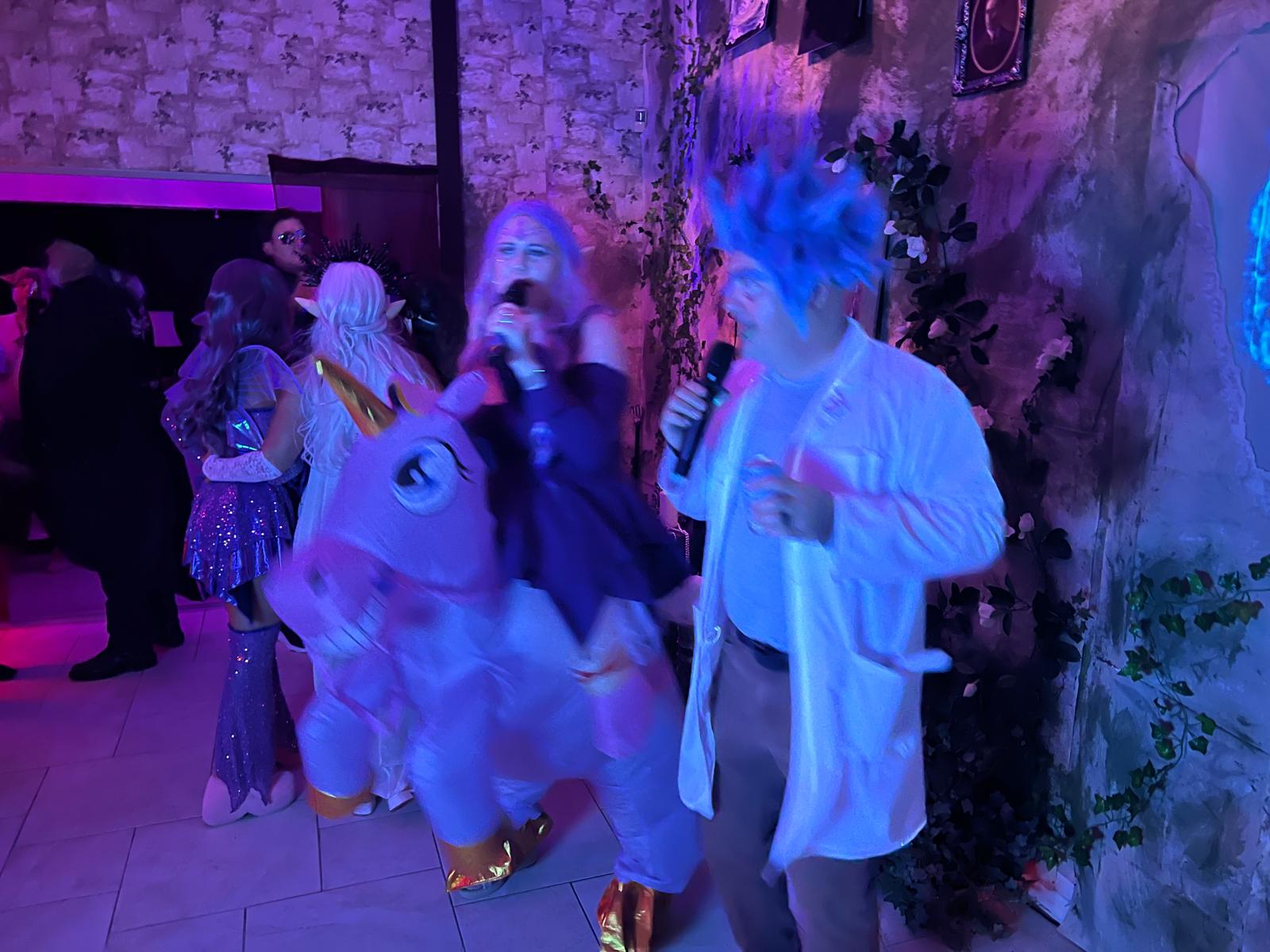 Guests singing beside an inflatable unicorn during the 2024 party