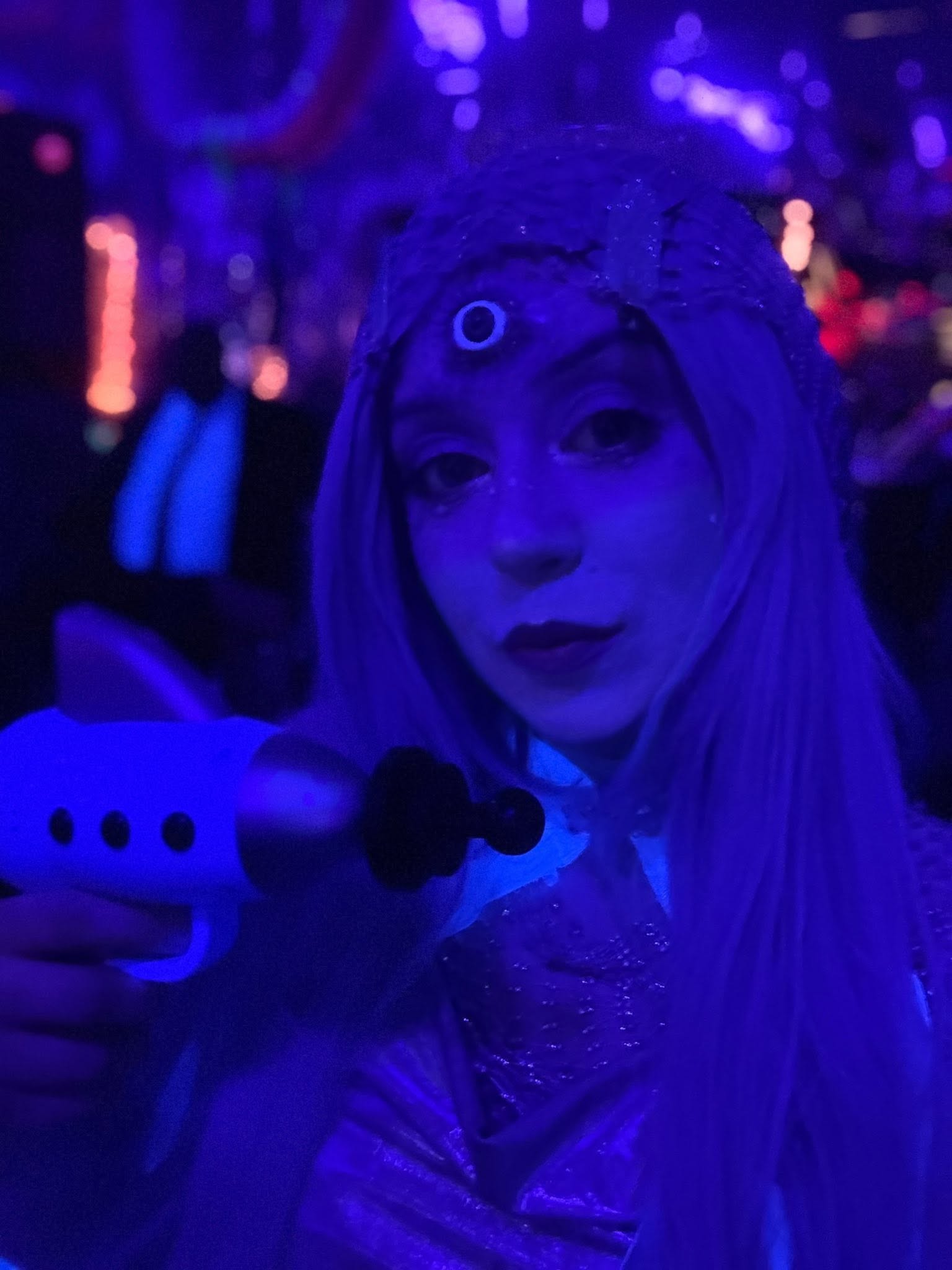 A close portrait of a guest with lavender hair aiming a retro ray gun at The Space Station in 2025