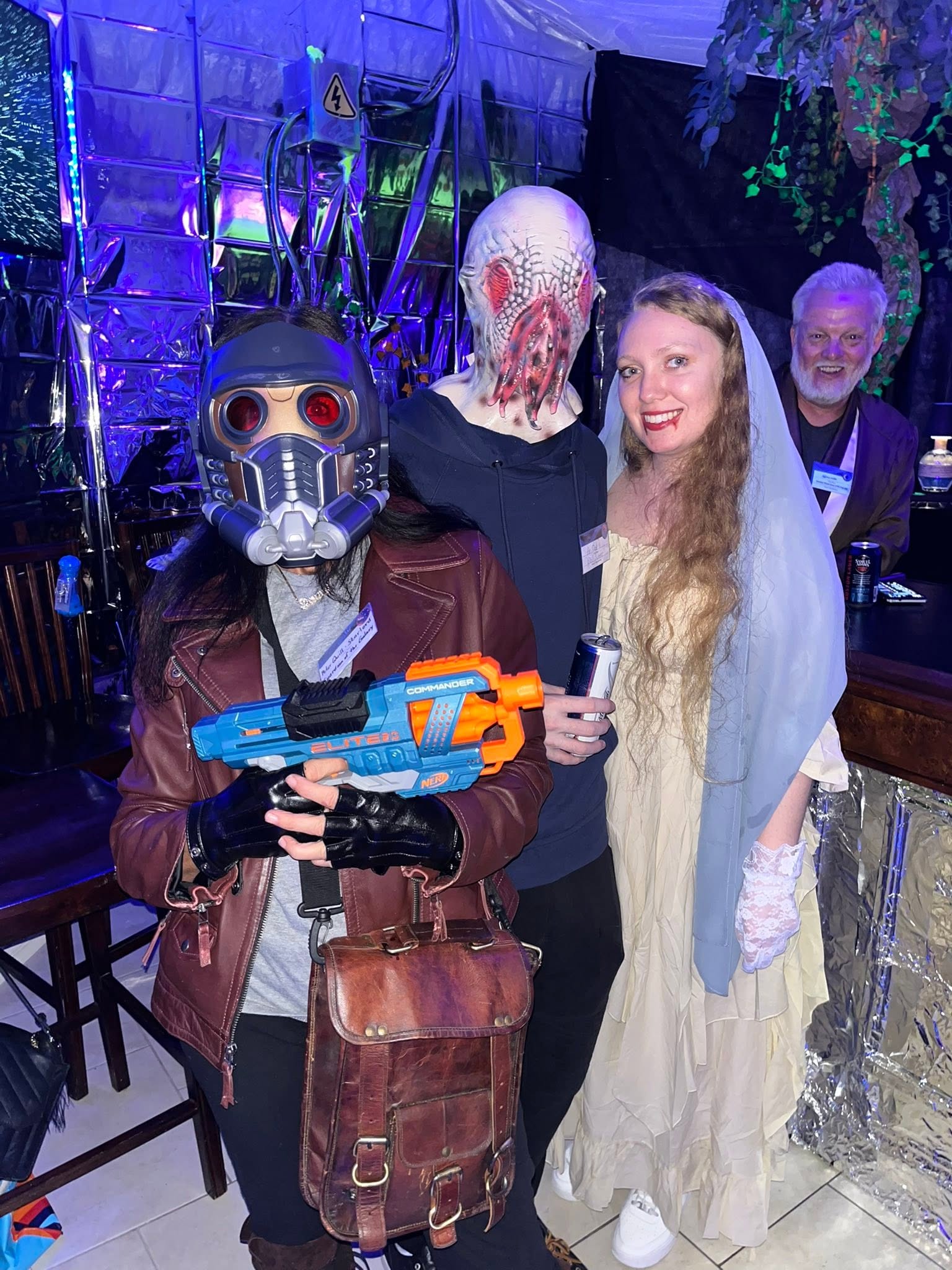 A group portrait featuring a masked space outlaw, a monstrous alien, and a ghostly bride at The Space Station in 2025